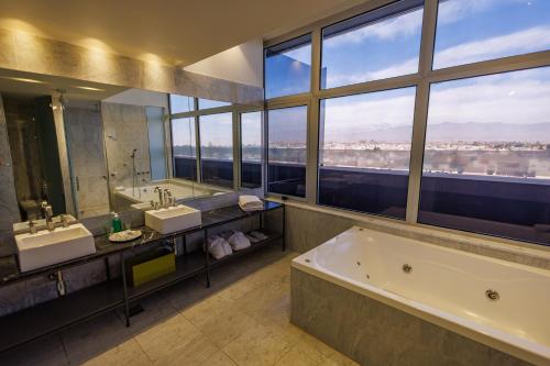 a large bathroom with two sinks and a bath tub at Esplendor by Wyndham Mendoza in Mendoza