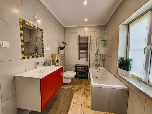 a bathroom with two sinks and a tub and a toilet at Holiday Home Vegas - HOUSE AND GARTEN FOR EXCLUSIVE USE in Kołczewo