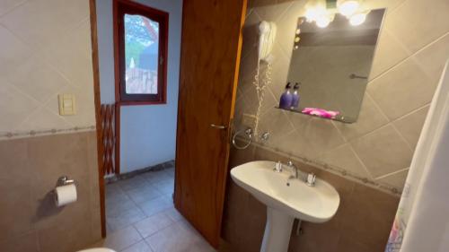 uma casa de banho com um lavatório e um espelho em Complejo Sol Serrano em Mina Clavero