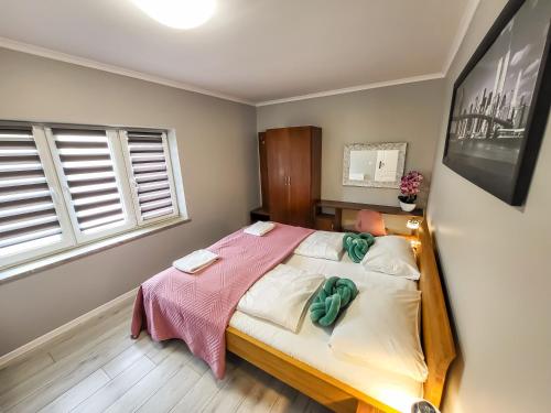 a bedroom with a bed with a pink blanket at Holiday Home Vegas - HOUSE AND GARTEN FOR EXCLUSIVE USE in Kołczewo