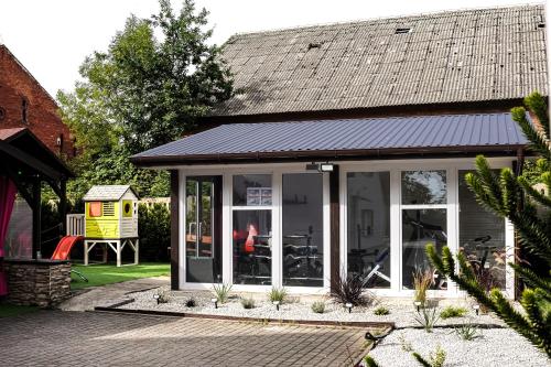 a conservatory with a solar roof on a house at Holiday Home Vegas - HOUSE AND GARTEN FOR EXCLUSIVE USE in Kołczewo