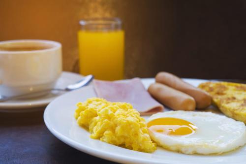 a plate of eggs and toast and a cup of coffee at Casa hotel Mateguadua in Apartadó