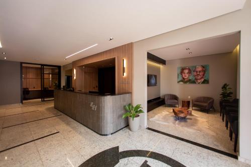 a lobby with a reception desk and a living room at Luz Hotel Pato Branco in Pato Branco