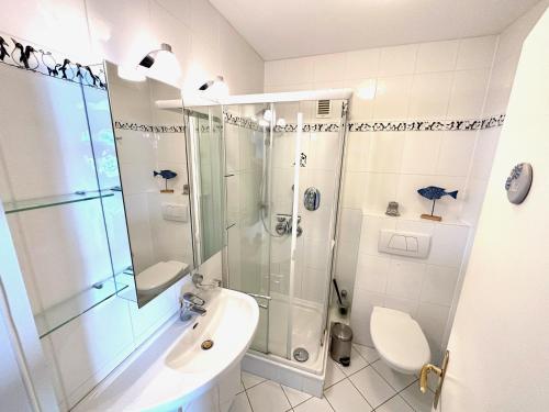 ein Badezimmer mit Dusche, Waschbecken und Toilette in der Unterkunft Silbermöwe - Traumhafter Meerblick in Cuxhaven