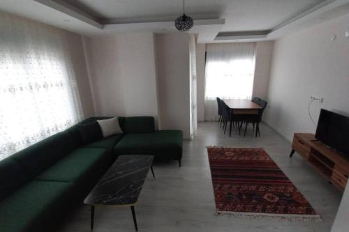uma sala de estar com um sofá verde e uma mesa em Saray park em Alanya