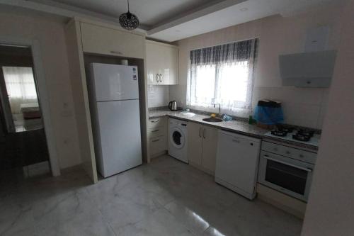 uma cozinha com um frigorífico branco e uma máquina de lavar louça em Saray park em Alanya