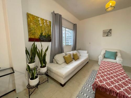 - un salon avec un canapé blanc et une fenêtre dans l'établissement Suite Tierra - The Garden House, à Pedro Vicente Maldonado