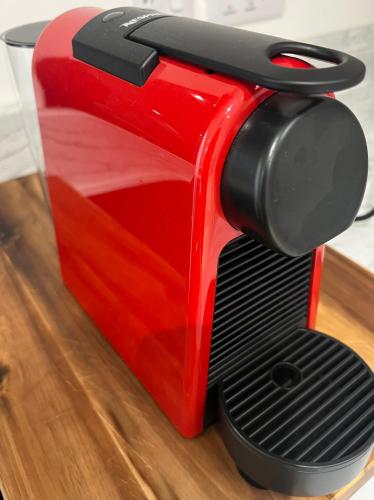 a red toaster sitting on top of a wooden floor at The Apartment Cold Comfort Farm in Hinckley