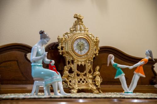 un groupe de figurines à côté d'une horloge d'or dans l'établissement Apartman Centar, à Sremski Karlovci