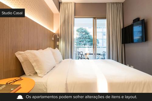 a hotel room with a bed and a tv at Charlie Girassol Vila Madalena in Sao Paulo