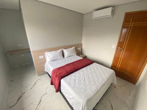 a bedroom with a bed with a red blanket on it at Hotel Fênix Belenzinho in Sao Paulo