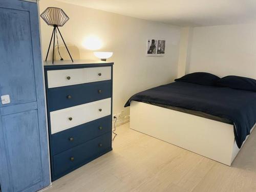 - une chambre avec une commode bleue et blanche et un lit dans l'établissement Le Ptit Parisien - Champs Élysées - Métro & Wifi, à Paris