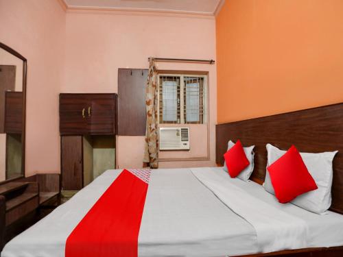 a bedroom with a large bed with red pillows at OYO Flagship Jaiswal Star Stay in Lucknow