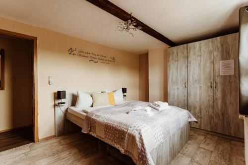 ein Schlafzimmer mit einem Bett mit einer Holzwand in der Unterkunft Waldrandzauber in Benneckenstein