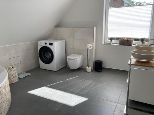 a bathroom with a washing machine and a toilet at Ferienwohnung kleines Glück in Lübeck