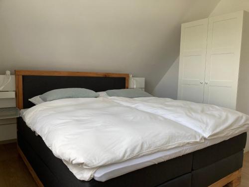 a bedroom with a large bed with white sheets at Ferienwohnung kleines Glück in Lübeck