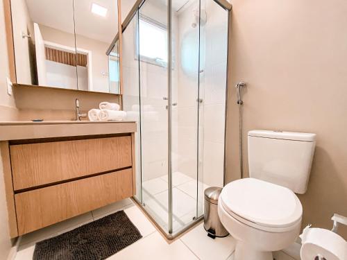 uma casa de banho com um WC e uma cabina de duche em vidro. em Luxuoso Apto 2Q Jd Goiás - 1103T em Goiânia