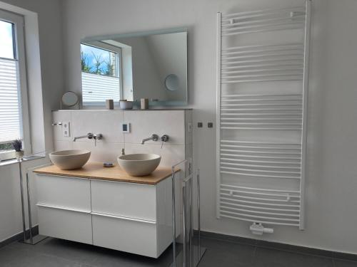 a bathroom with two sinks and a mirror at Ferienwohnung kleines Glück in Lübeck