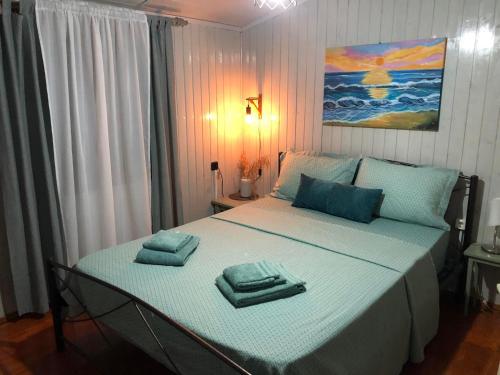 a bedroom with a large bed with towels on it at Cozy Home Kanali, Preveza in Kanali