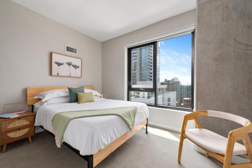 ein Schlafzimmer mit einem Bett und einem großen Fenster in der Unterkunft Xl apartments at the GoldCoast- Cloud9-833 in Chicago