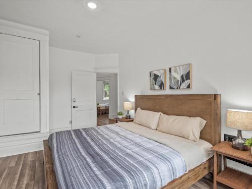 a bedroom with a large bed with a wooden headboard at Oakland/University @E Stylish and Central Private Bedroom with Shared Bathroom in Pittsburgh