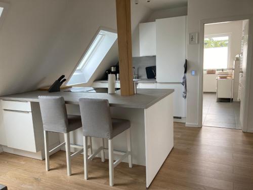 a kitchen with a counter and some chairs in it at Ferienwohnung kleines Glück in Lübeck