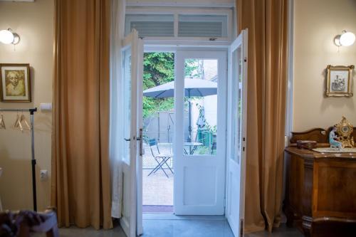 an open door leading to a patio with an umbrella at Apartman Centar in Sremski Karlovci