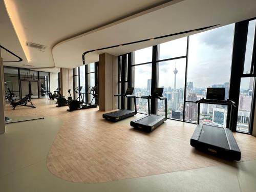 a gym with cardio equipment in a building with windows at Axon Residence By Perkasa Suites in Kuala Lumpur