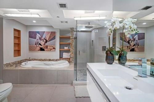 uma casa de banho com uma banheira, um WC e um lavatório. em Over The Moon! Miami Skyline and Water Views! em Miami