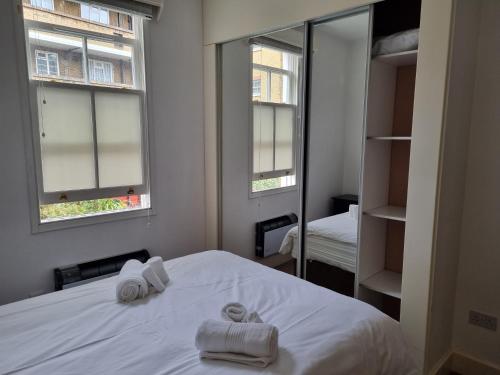 a bedroom with two towels on a bed with a mirror at Stunning 2 Bed/2 Bath Flat in Waterloo, London in London