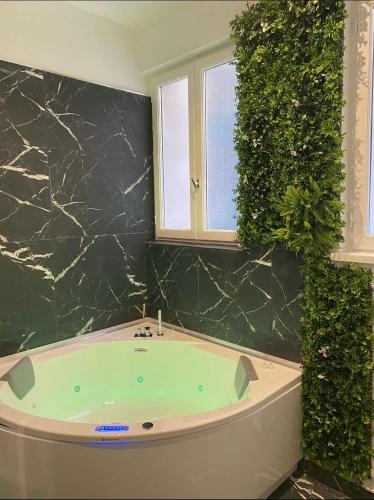 a bathroom with a jacuzzi tub next to a window at Escapade Urbaine - Balnéothérapie - Cinéma au Cœur de la Ville in Mâcon