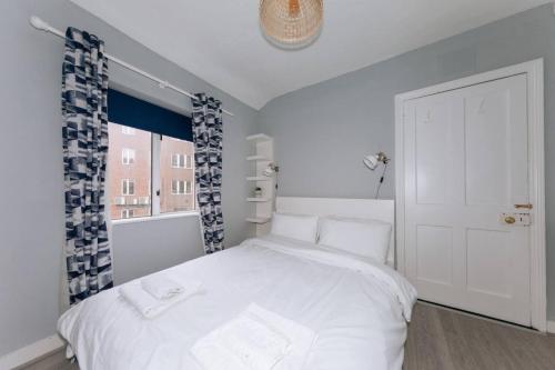 a bedroom with a white bed and a window at Centrally Located & Spacious 4BD House- St Kevin's in Dublin
