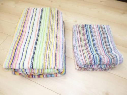 two striped towels sitting on a tile floor at The Mickey Carlton Ohashi Alpha Coat - Vacation STAY 15164 in Fukuoka