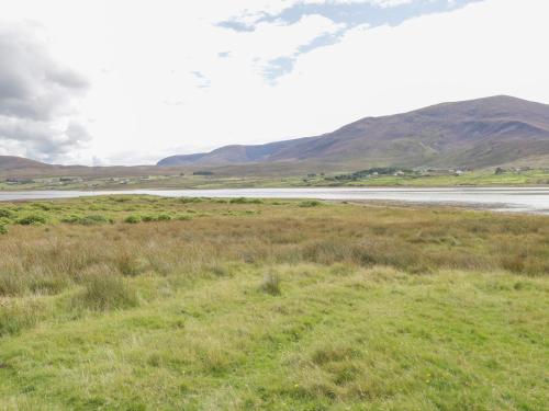 a field with a river and mountains in the background at Sound Cottage in Sraheens