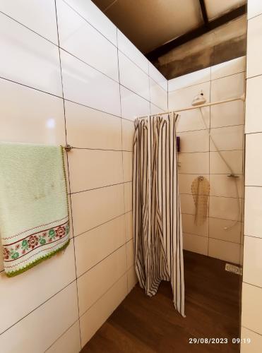 a bathroom with white tiled walls and a towel at Casa com piscina e Quiosque! in Encantado