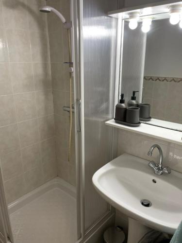 une salle de bain blanche avec une douche et un lavabo dans l'établissement Holiday Studio Calvi, à Calvi
