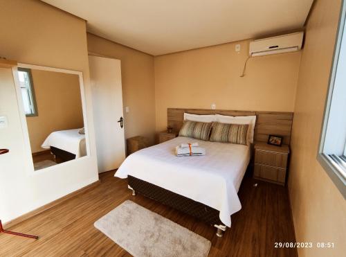 a bedroom with a large bed and a mirror at Casa com piscina e Quiosque! in Encantado