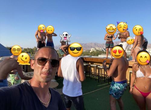 a man standing in front of a group of people wearing rubber helmets at Amdar Hostel in Eilat