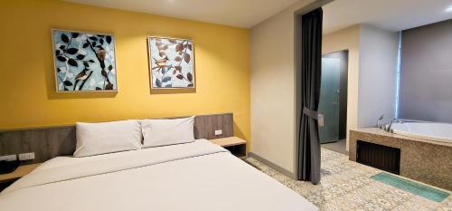 a bedroom with a bed and a tub and a sink at Recenta Suite Phuket Suanluang in Phuket Town