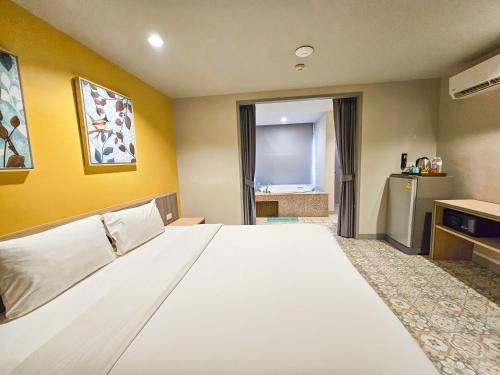 a large bed in a room with yellow walls at Recenta Suite Phuket Suanluang in Phuket Town