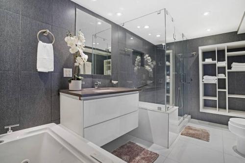 een badkamer met een bad, een wastafel en een douche bij Seas The Day! Complete Panoramic Water Views in Miami