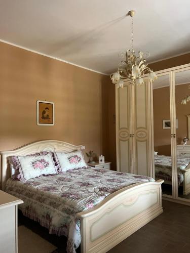 a bedroom with a bed and a chandelier at Villa Rosaria in Tollo