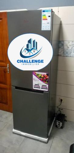 a refrigerator with a sign on the side of it at Appartement meublé in Douala