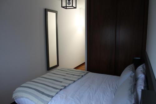Schlafzimmer mit einem weißen Bett und einem Spiegel in der Unterkunft CAMINO INGLES Habitación Luxe doble Baño y cocina in A Coruña