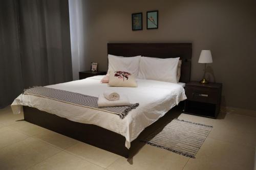 a bedroom with a large bed with two towels on it at Nakheel Residence Sabah Alsalem by House living in Kuwait