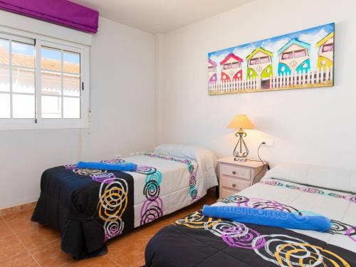 a bedroom with two beds and a painting on the wall at Casa del Sol in Salobreña