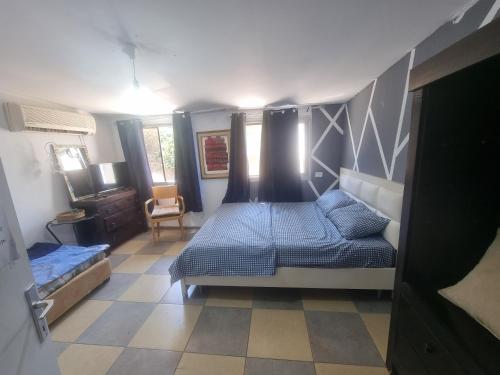 a bedroom with a bed and a chair in it at בית על חצי דונם במרכז קרית שמונה in Qiryat Shemona