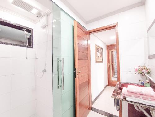 ein Bad mit einer Glasdusche und einem Waschbecken in der Unterkunft Hospedagem Stein - Suíte 402 in Domingos Martins