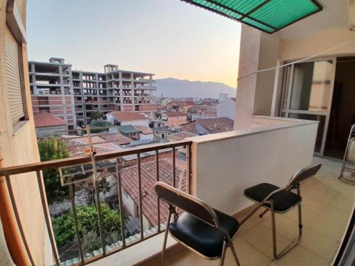2 stoelen op een balkon met uitzicht op de stad bij Cozy apartment in the city center 2 in Shkodër