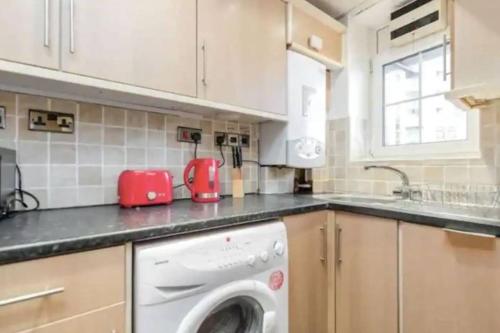 une cuisine avec un lave-linge sur un comptoir dans l'établissement APlaceToStay Central London apartment, Zone 1 LEIC, à Londres